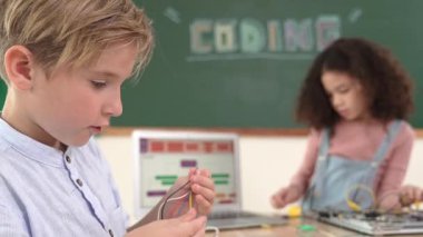 Dizüstü bilgisayar ekranında çalışan çeşitli öğrenci kodlama mühendisliği komut yazılımı ve yapay zeka programlaması yapıyor. Amerikalı kız, erkek makine tamir ederken ekipmanları teftiş ediyor. Pedagoji.