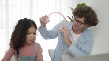 Beyaz bir baba kızına kulaklık takarken kız da kod öğreniyordu. Babam, mühendislik öğretirken liseli kızla ilgilenir ve dizüstü bilgisayar kullanarak Ai üretir. Çevrimiçi öğrenme. Pedagoji.