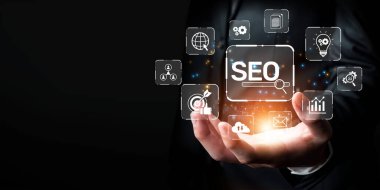 SEO ile ilgili çeşitli simgeleri gösteren, dijital pazarlama stratejilerinde arama motoru optimizasyonunun önemini sembolize eden parlak bir arayüz tutan profesyonel bir el. XDMCP