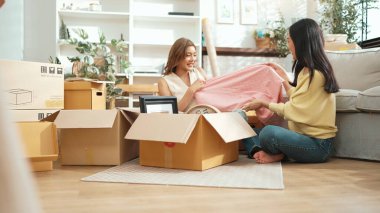 Kutuları açan ve mobilyaları toplayan mutlu arkadaş manzarası. Karton kutuyla çevrili oturma odasında konuşurken yeni daireye taşınan çekici bir genç. Malikane. Myrmidon.