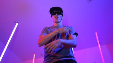 Beyaz dansçının gösterişli gözlükler taktığı ve break dans yaptığı alçak açılı kamera. Çekici adam kendinden emin bir şekilde kameraya bakarken enerjik bir performans ve hareket gösterdi. Mutluluk.