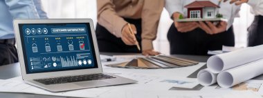 İç mimar tasarımcı grubu, daha kesin tasarım için planlar ve dizüstü bilgisayar ekran mimari yazılımı üzerinde birlikte tartışıyorlar. Modern ev tasarımı ve yenileme. İçgörü