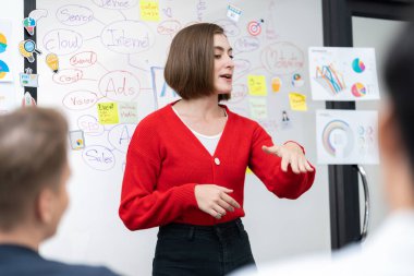 Profesyonel çekici kadın lider, modern iş toplantı odasında beyin fırtınası zihin haritalama istatistikleri ve renkli yapışkan notlar kullanarak yaratıcı pazarlama planını sunuyor. Tertemiz..
