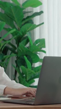 Masasında dizüstü bilgisayarla çalışan kulaklık ve mikrofon takan Asyalı müşteri destek operatörü. Hevesli kadın çalışanlar müşteri hizmetleri sunuyor, destekleyici çağrı merkezi temsilcisi müşterilere yardım ediyor.