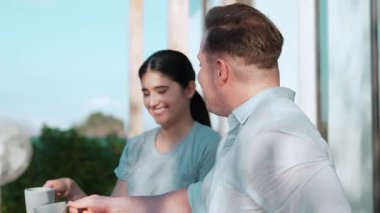 Kahve fincanı olan orta yaşlı bir çift güzel olaylardan ya da terasta haberlerden bahseder rahatlar ve sohbet ederler. Neşeli anne ve babanın mutlu bir ilişkileri ve güçlü bir aile bağları vardır. Uyumsuzluk.