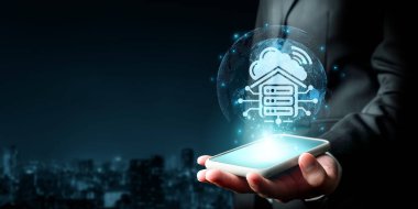 Bir işadamı, modern teknoloji ortamlarında çevrimiçi hizmetler ve veri yönetimi kavramını gösteren bulut hesaplama grafiklerini gösteren bir akıllı telefon tutuyor. XDMCP