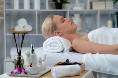 Kafkasyalı kadın müşteri stres önleyici spa masajının keyfini çıkarıyor ve lüks otel ya da oteldeki gündüz açık ortam güzellik salonunda güzellik teniyle eğleniyor. Sessiz.