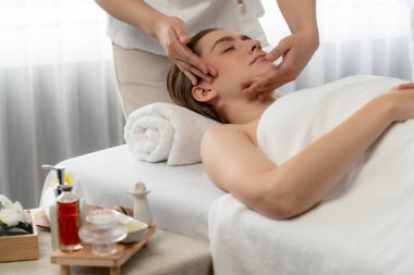 Kafkasyalı kadın stres önleyici kafa masajından ve lüks tatil beldesi ya da otel spa salonundaki modern ışık ortamında yüz güzelliği eğlencelerini şımartmaktan hoşlanıyor. Sessiz.