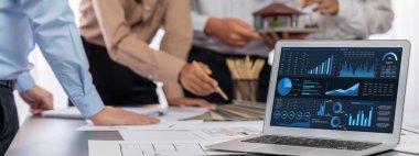 İç mimar tasarımcı grubu, daha kesin tasarım için planlar ve dizüstü bilgisayar ekran mimari yazılımı üzerinde birlikte tartışıyorlar. Modern ev tasarımı ve yenileme. İçgörü