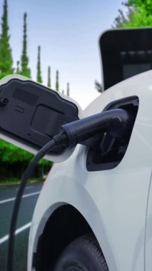 Elektrikli araç konsepti, yeşil çevre için yenilenebilir ve temiz enerjiyle çalışan EV otomobilinin varış noktasına ulaşmadan önce ormandaki şarj istasyonunun enerjisini şarj etmek için durur..