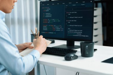 Çevrimiçi web sitesinin bilgisayar ekranında kodlama programı uygulamasına bakan akıllı bilişim geliştiricisi, modern ofisteki iş dünyası pazarında akıllı veritabanı geliştirme sistemini analiz ediyor. İnfobahn.