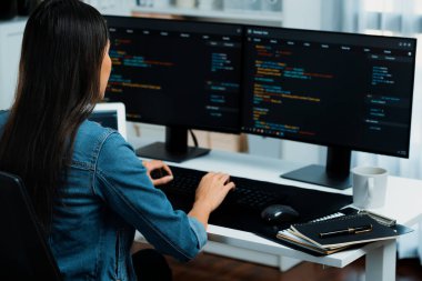 İnternet sitesi uygulamasının kodlama verileriyle birlikte online bilgi yazarak kot gömlek giyen genç Asyalı geliştirici. Güvenlik analizi ile çevrili iki ekran. Taktik.