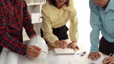 Mimari döküman, ölçüm araçları ve ahşap blokların modern ofiste etrafa saçıldığı masa üzerine planlar yapma konusunda akıllı mimar ve güvenlik mühendisi tartışması. - Yakın çekim. Tanımlama.