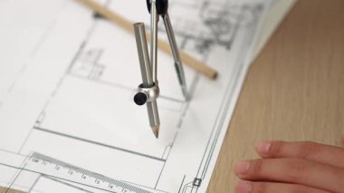 Bölücü araç ve el yazısı kullanan akıllı mimar ya da güvenlik mühendisinin videosu mimari ofisteki inşaat doğruluğu planının ayrıntılarını içeriyor. Eline odaklan. - Yakın çekim. Tanımlama.