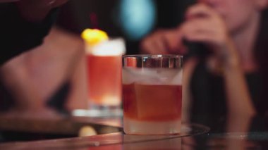 Barmen portakal kabuğu sıkıyor cam kokteyl viskisinin üzerinden kokuyor buzun üstüne Old Fashioned koyuyor Paloma 'da özel içki reklamı alkolü ve misafir geçmişi yapıyor. Vinosity.