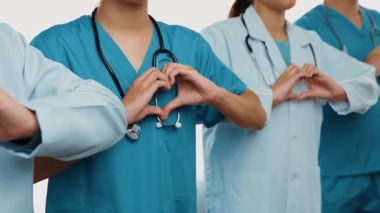 Profesyonel sağlık personeli kuyrukta bekleyip, birlikte el kaldırarak sağlık hizmetleri ve hastanedeki doktor liderliğini sembolize ediyorlar. Takım çalışması başarılı tedaviye yol açar. Düşük hareket. Katı.