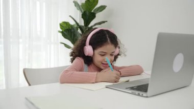 Kulaklık takıp ödevlerini yapan sevimli bir Amerikalı kız. Programlama sistemini araştırırken ve mühendislik komut yazarken defterde yazan mutlu çekici kız öğrenci. Pedagoji.