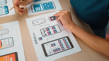 Mobil uygulama için kullanıcı arayüzü prototipi ya da masadaki program modeliyle birlikte web sitesi planlaması yapan bir şirket çalışanı. UX UI tasarımcısı kullanıcı dostu arayüz planını dikkate alır. Sinerjik