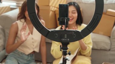 Kadın girişimci çevrimiçi pazarlama platformu kullanarak ürünü sunmaya başlarken çevrimiçi canlı yayın platformunda insanları selamlıyor. Çekici satıcı ya da etkili kayıt videosu. Myrmidon.