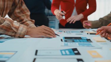 Çeşitli profesyonellerden oluşan bir grup, yaratıcı bir beyin fırtınası yaparak modern bir çalışma alanında iş birliği yapıyor. Dijital modeller ve notlar masayı kaplıyor. SACTR