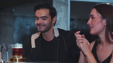 Barmen, dumanlı klasik viskiyi kokteyl ile karıştırıyor. Bir bayana içki tadıyor ve kulüpteki grup misafirlerine içecek tezgahında lezzetli bir içki ikram ediyor. Vinosity.