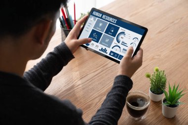 Human resources management software on computer screen helping human resources employee to manage recruitment, payroll, staff searching and KPI evaluation snugly