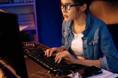 Genç, Asyalı yaratıcı bir kadının satış hedefi raporundan elde ettiği karı analiz etmesi, e-posta ile iş piyasası raporlarını karşılaştırması, gece neon ışığı altında not defterine not yazması. Taktik.