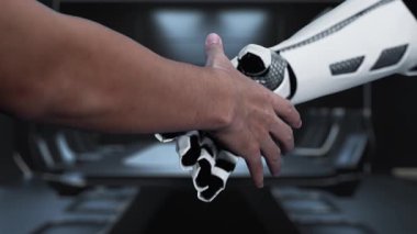 Bir insan elinin modern ofis ortamında temas simgeleriyle robotik bir ele uzandığını gösteren bir video, gelecekteki iletişim ve işbirliğini sembolize ediyor. Auvana