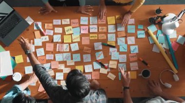 Akıllı proje yöneticisinin konuşmasının ve fikir ve alkışlamayı açıklamasının üst görüşü. İş dünyasının havadan görünüşü başarılı projeyi alkışlıyor. Toplantı odasında el çırpma takımının hava görüntüsü. Sempozyum.