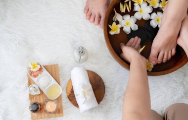 Kadınlar lüks spa salonlarında keyifli ayak masajlarına devam ederken, masör de hafif gün ışığı atmosferinde refleksoloji terapisi veya otel ayak spa 'sında. Sessiz.