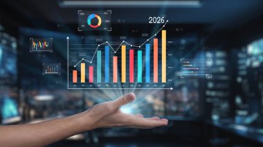 Modern bir el, 2026 yılı için çeşitli iş grafikleri ve projeksiyonlarını gösteren fütüristik bir arayüz bulundurur. Bu görüntü, analitikteki büyüme ve yeniliği temsil ediyor. Auvana
