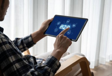 İş adamı B2B peyzajında geziniyor, iş-iş bağlantılarını geliştirmek için kullanım teknolojisi kullanıyor. B2B etkileşimini yeniden şekillendiren keşifler, iş-iş stratejilerinde yenilikleri yönlendiren araçlar. canlı