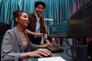 Bilgi teknolojisi geliştiricileri modern ofisteki neon ışık odasında verileri çevrimiçi olarak çalıştıran akıllı web sitesi geliştirme kodlayıcı sistemine işaret ediyorlar. İnfobahn.