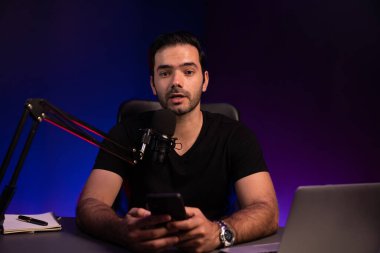 Canlı yayında dinleyiciyle konuşan yayıncı, Mor Neon Işık Stüdyosu 'ndaki yaratıcı pozitif düşünce konseptiyle sosyal medyada akıllı telefondan mesajları kontrol ediyor. Tahmin et..