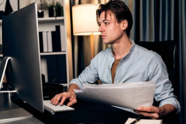 Akıllı işadamı klavyesini monitörde, iş paragrafı dinamik veri pazarlama analizi tablosu ile birlikte gece vakti modern merkez büroda rapor evrakları üzerinde daktilo ediyor. Bireysel.