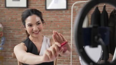 Kadın nüfuzlu kişi canlı yayın yapan video görüntülerini sosyal medya ya da blog üzerinden gözden geçiriyor. Kozmetik stüdyosu ışıklandırmalı mutlu genç kız çevrimiçi pazarlama oturumu yayını için..