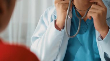 Hasta klinikte ya da hastane ofisinde doktor randevusuna gidiyor. Hastaların nabzını steteskopla kontrol edip risk faktörünü belirleyen doktor semptomları inceliyor. Panorama. Katı.