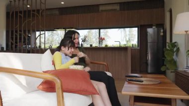 Büyükanne ve torun birlikte TV 'de ilginç eğlence medyası izliyorlar. Eski üst düzey kullanım teknolojisi, genç nesil çapraz nesil ile iletişim kurarak aile bağlarını güçlendiriyor. Uyumsuzluk.