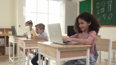 Amerikalı kız kodlama mühendisliğini öğrenirken çeşitli öğrenciler BTMM Teknoloji sınıfında oturuyor. Bilgisayarda çalışan çok kültürlü çocuklar yapay zeka üretmek için yazılım kullanıyorlar. Pedagoji.