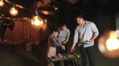 Aile birlikte bahçede kamp kurar, anne baba ve kız aile bireyleri için ızgara yapar. Doğayla iç içe olmak için açık hava kamp aktiviteleri ve genç nesil çapraz kuşaklarla zaman geçirmek için. Uyumsuzluk.