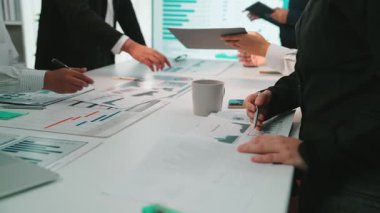Çeşitli bir iş ekibi verimli bir toplantıya katılıyor, stratejileri tartışıyor ve verileri grafikler ve grafiklerle analiz ediyor, modern bir ofiste işbirliğini teşvik ediyor. SACTR