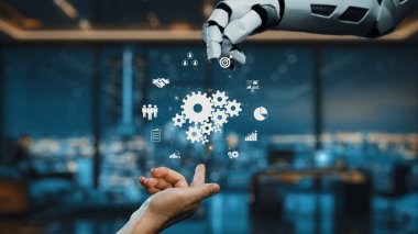 Modern bir ofiste, çeşitli dijital ikonlar tarafından temsil edilen teknoloji ve iş dünyası arasındaki bağlantıyı sembolize eden bir robot el insan eline uzanıyor. Auvana