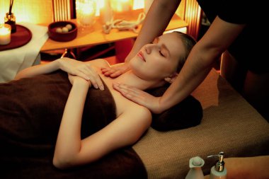 Beyaz kadın müşteri stres önleyici spa masajının keyfini çıkarıyor ve lüks otel ya da otelde sıcak mum ışığında güzellik teniyle eğleniyor. Sessiz.