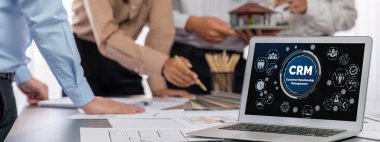 İç mimar tasarımcı grubu, daha kesin tasarım için planlar ve dizüstü bilgisayar ekran mimari yazılımı üzerinde birlikte tartışıyorlar. Modern ev tasarımı ve yenileme. İçgörü