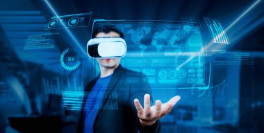 VR gözlüklü proje yöneticisi elinde mali tablo ve ofiste parlayan mavi ışık tutuyor. Yetenekli iş adamı artırılmış gerçeklikten elde edilen verileri kullanarak pazarlama stratejisini kontrol edip planlıyor. Yaratıcılık.
