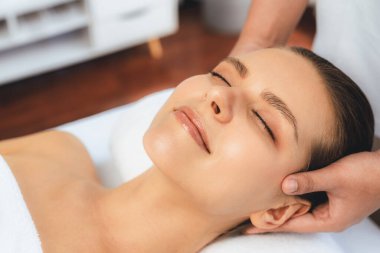 Kafkasyalı kadın stres önleyici kafa masajından ve lüks tatil beldesi ya da otel spa salonundaki modern ışık ortamında yüz güzelliği eğlencelerini şımartmaktan hoşlanıyor. Sessiz.
