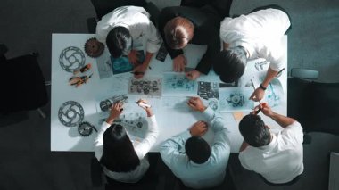 Türbin motor tasarımını gösteren ve hakkında konuşan yetenekli mühendisin en alt görüşü. Yetenekli tasarımcı veya teknisyen grubunun hava görüşü elektronik jeneratör inşaatını açıklıyor. Hizalama.