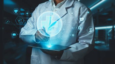 Stylus kalemle laboratuvarda yüzen tıbbi çapraz hologramı işaret ederken, doktorun tableti tutuş şeklini kapat. Pratisyen hekim teknolojiyi kullanarak ikonu kontrol ediyor ve bakıyor. İyileştirici.