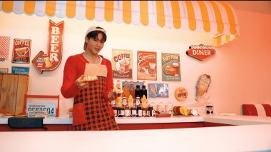 Profesyonel Asyalı restoran işçisi yemek hazırlar ve yemek barının arkasında durur. Kırmızı gömlekli ve kırmızı önlüklü mutlu garson kameraya bakarken serbest stil müziğe geçiyor. Çılgın dans. Mutluluk.