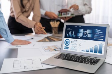 İç mimar tasarımcı grubu, daha kesin tasarım için planlar ve dizüstü bilgisayar ekran mimari yazılımı üzerinde birlikte tartışıyorlar. Modern ev tasarımı ve yenileme. İçgörü